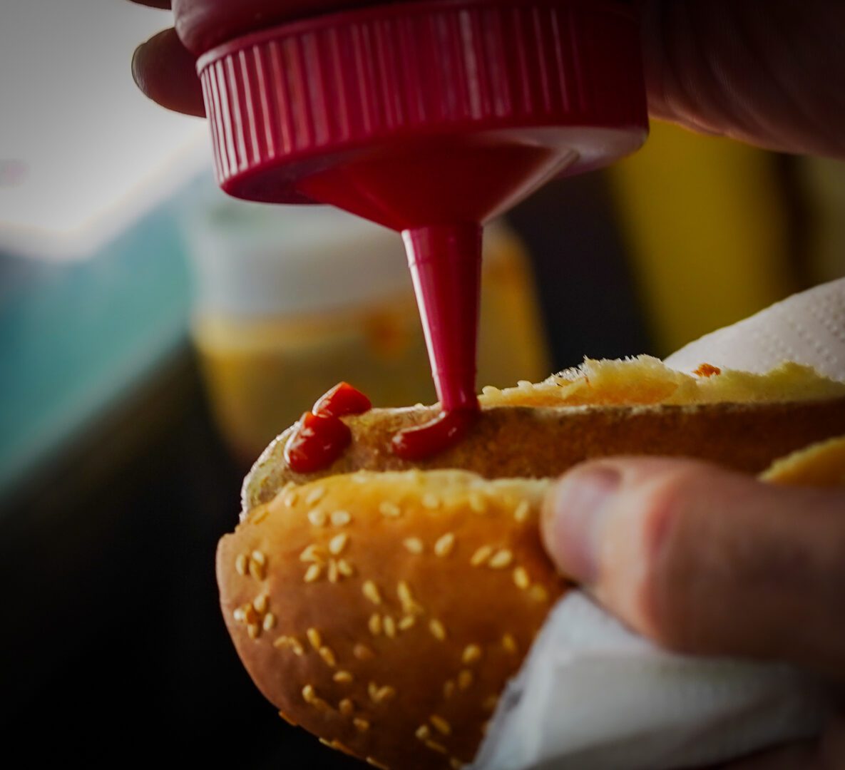 Close-up of adding ketchup to sandwich