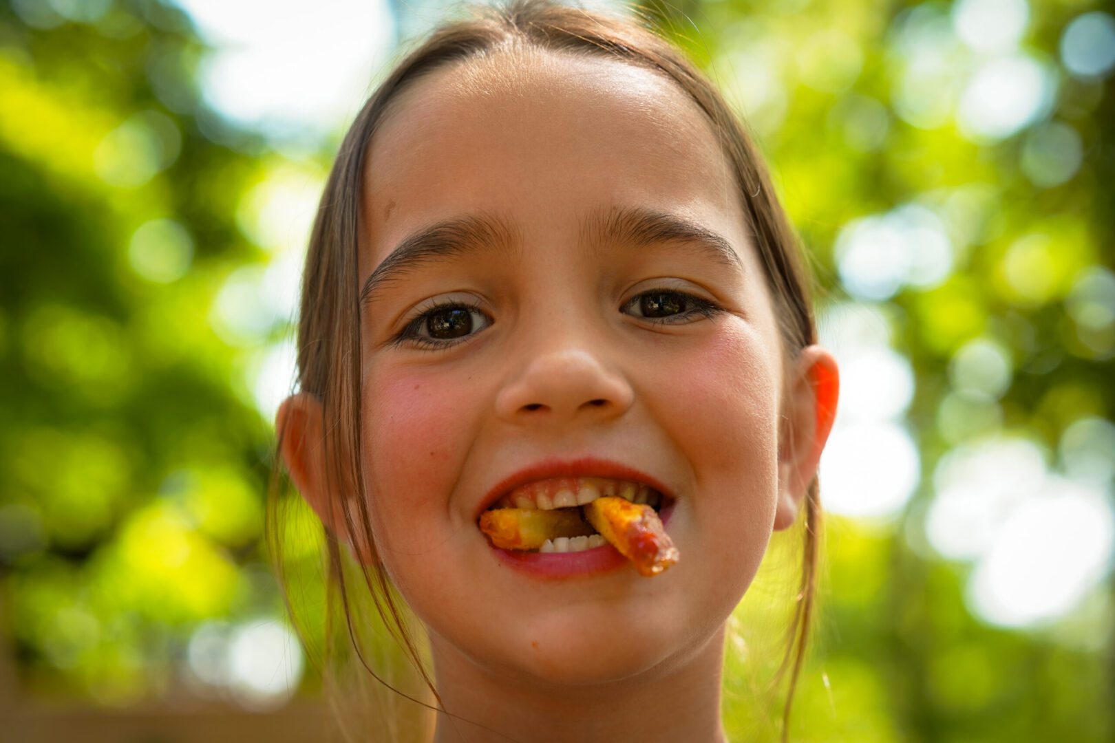 Smiling child with food in mouth