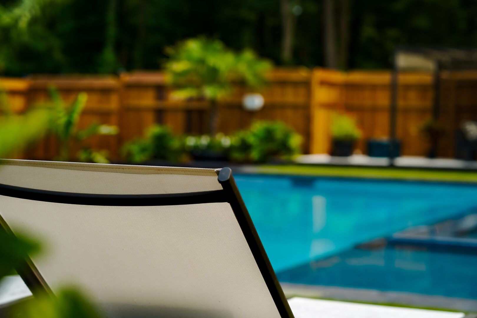 Outdoor pool scene with greenery and chair